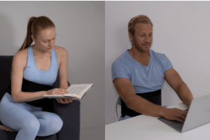 Woman sitting on sofa, man with laptop wearing Prime Science Fat Freezing belts on stomach