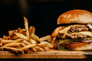 Burger and fries on wooden table 