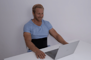 Man using Prime Science Fat Freezing belts in front of laptop